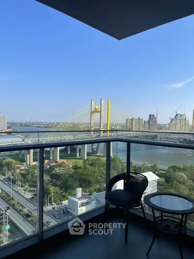 Stunning balcony view of city skyline and river with modern bridge.