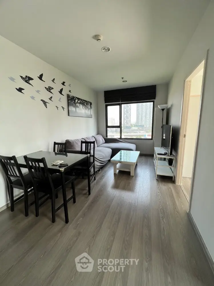 Modern living room with stylish decor and city view, featuring cozy seating and dining area.