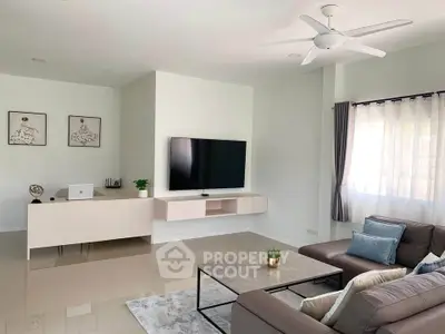 Modern living room with sleek furniture and large TV, perfect for relaxation and entertainment.