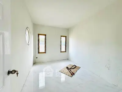 Spacious empty room with marble flooring and two windows, ideal for customization.