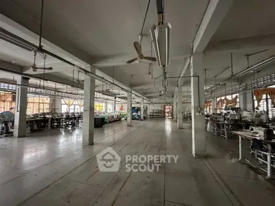 Spacious industrial-style interior with high ceilings and ample natural light, ideal for creative workspace or studio.
