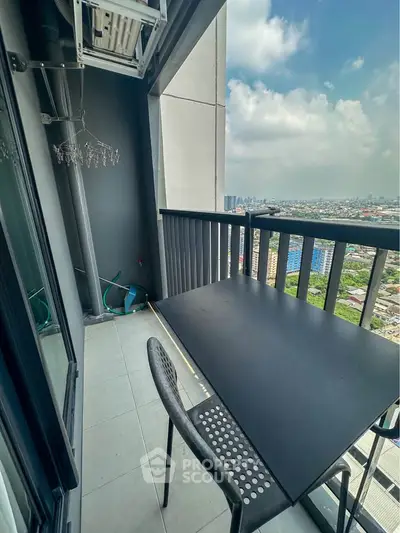 Modern balcony with city view, featuring sleek black table and chair, perfect for urban living.
