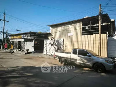 Commercial building exterior with modern design and ample parking space.