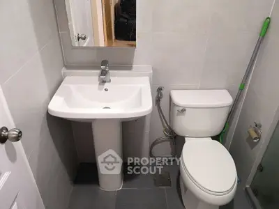 Compact bathroom with modern fixtures and neutral tiles