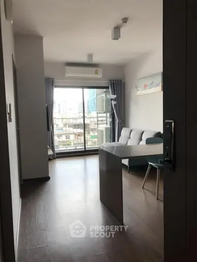 Modern living room with city view, featuring sleek furniture and large windows.