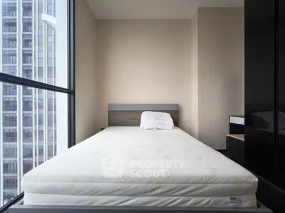 Modern bedroom with large window and city view, featuring a comfortable bed and minimalist design.