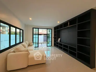 Spacious modern living room with large windows and built-in shelving