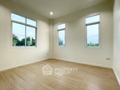 Spacious empty room with large windows and tiled flooring, perfect for customization.