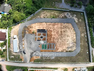 Aerial view of a large, undeveloped plot of land with surrounding greenery, ideal for new construction projects.