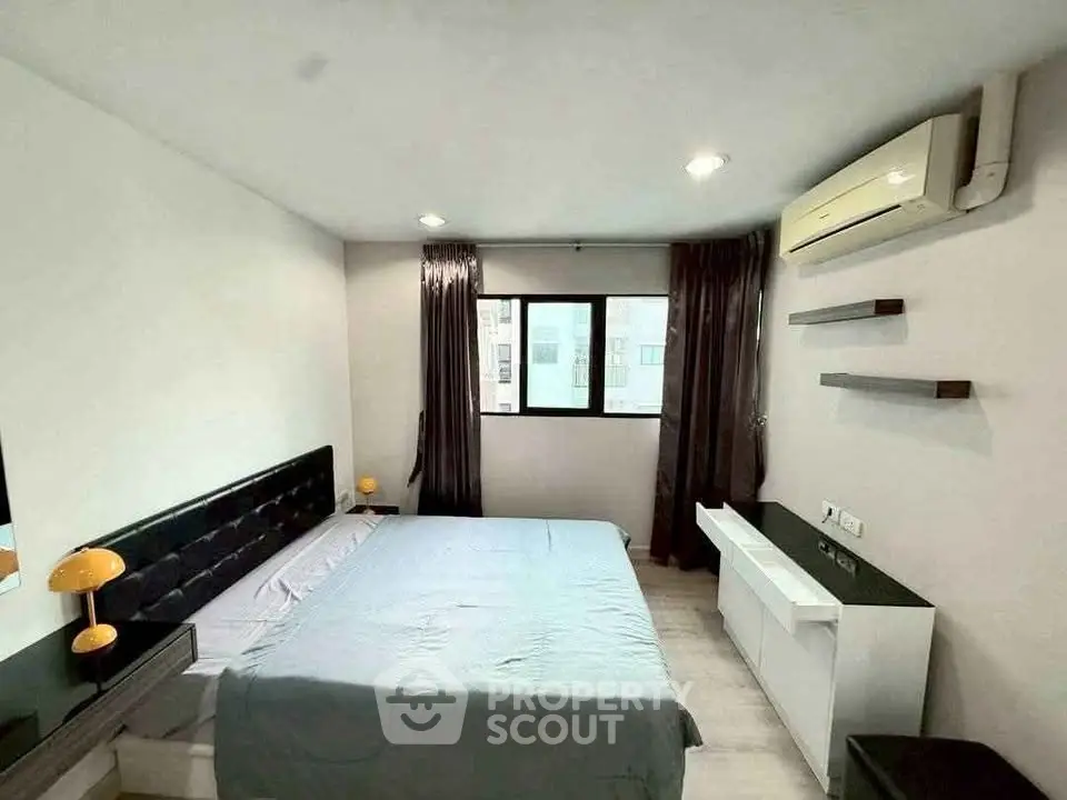 Modern bedroom with sleek design, featuring a large bed, air conditioning, and ample natural light.