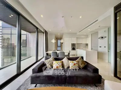 Luxurious modern living room with panoramic city views and sleek open kitchen layout.