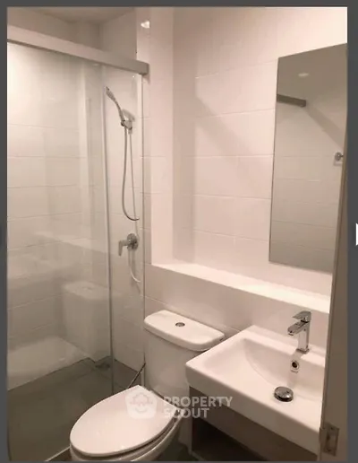 Modern bathroom with glass shower and sleek fixtures in a contemporary apartment.