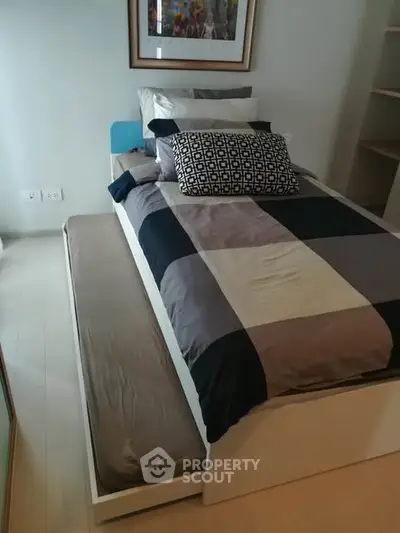 Modern bedroom with stylish bedding and pull-out trundle bed for extra space.