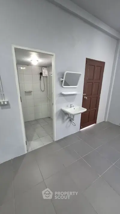 Compact bathroom with shower and sink in modern apartment