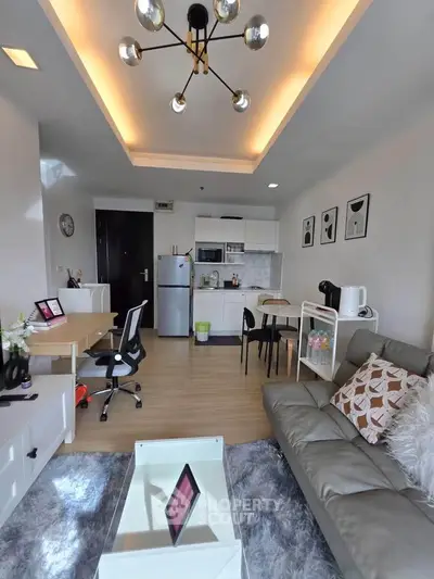 Modern living room with stylish decor and open kitchen layout, featuring cozy seating and contemporary lighting.