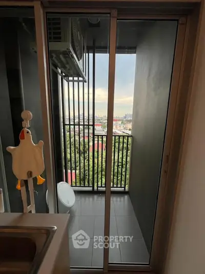 Modern apartment balcony with city view and sliding glass door, perfect for urban living.