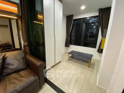 Modern living room with sleek design and large windows, featuring a cozy sofa and stylish coffee table.