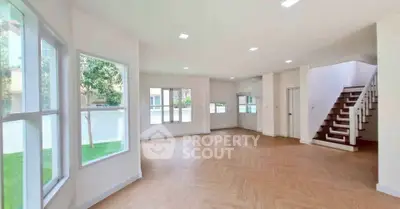 Spacious modern living room with large windows and wooden flooring