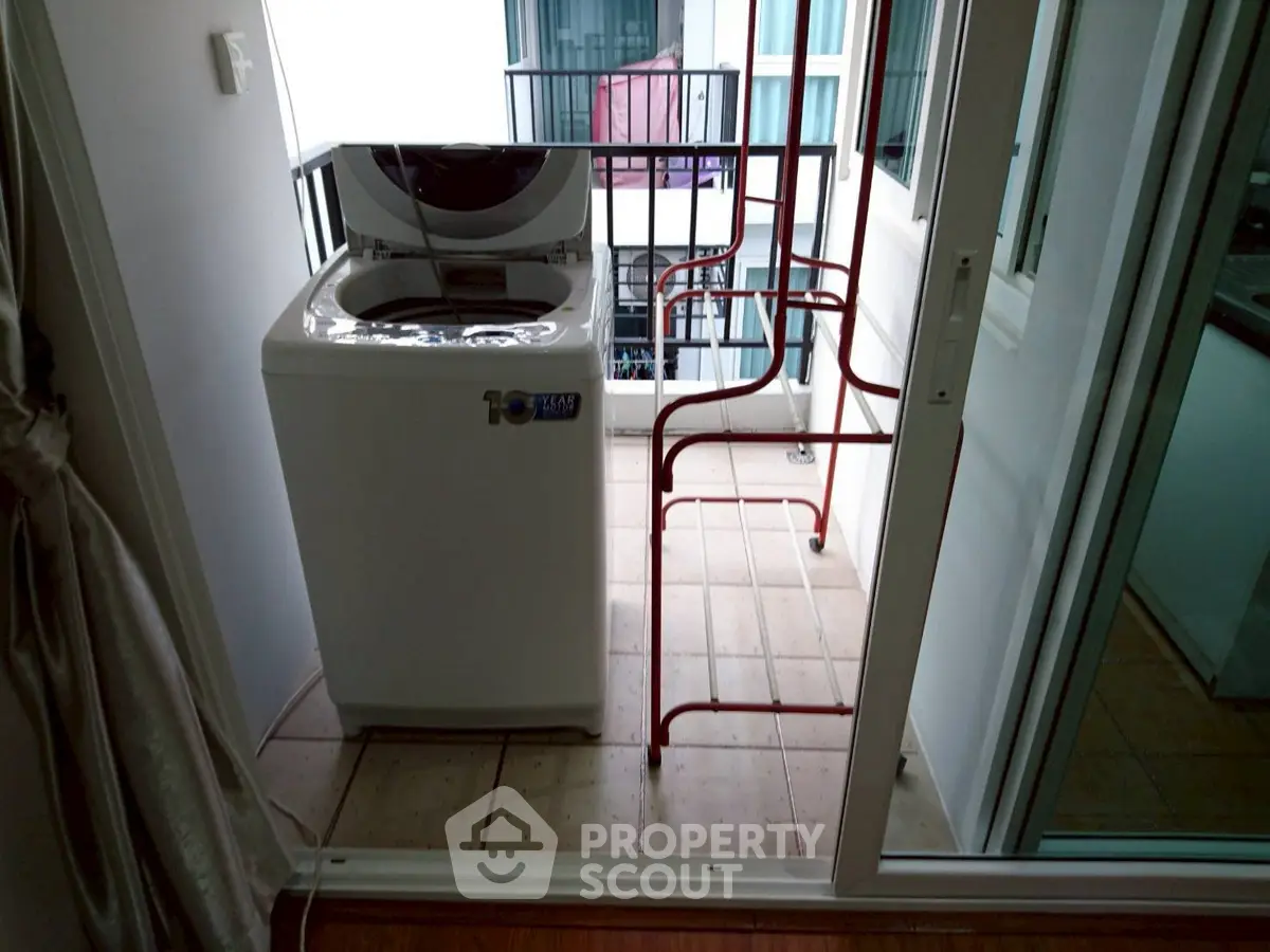 Compact balcony with washing machine and drying rack in modern apartment