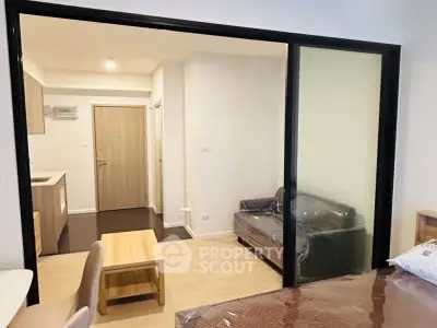 Modern apartment interior with sliding glass doors and cozy living area.