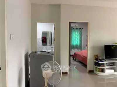 Modern apartment interior with washing machine and TV in living area