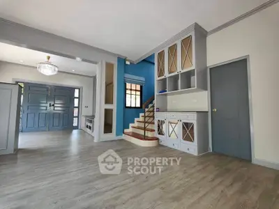 Spacious modern living room with elegant staircase and stylish cabinetry