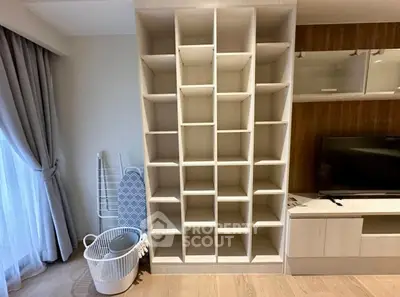 Modern living room with stylish shelving unit and TV stand, perfect for organizing and entertainment.