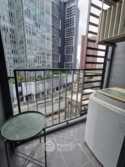 Modern urban balcony with city view, featuring a compact table and washing machine, ideal for city living.