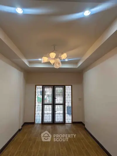 Spacious room with elegant lighting and wooden flooring, perfect for a cozy living area.