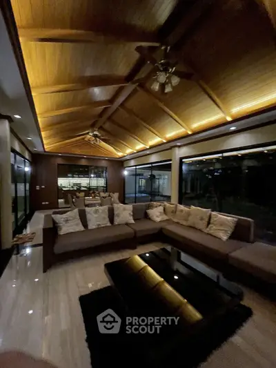 Luxurious living room with high wooden ceiling and elegant lighting
