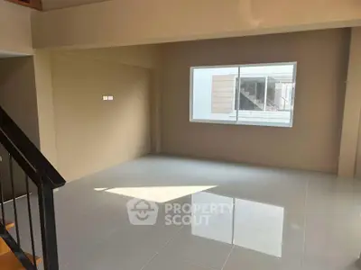 Spacious empty room with large window and glossy tiled floor