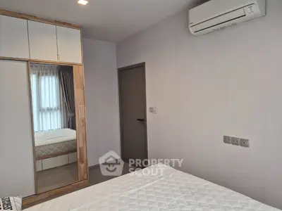Modern bedroom with built-in wardrobe and air conditioning in a stylish apartment.