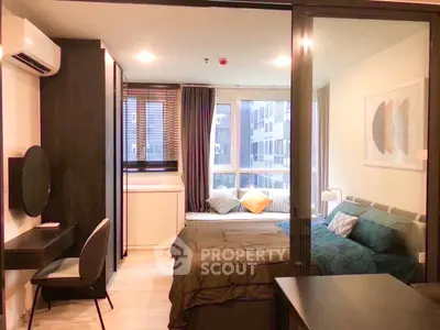 Modern bedroom with stylish decor and city view, featuring a cozy bed and workspace.