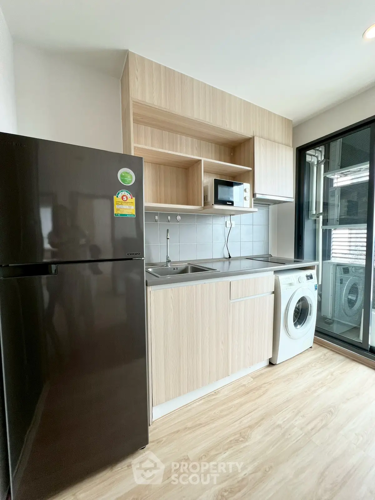 Modern kitchen with sleek appliances and washing machine in stylish apartment
