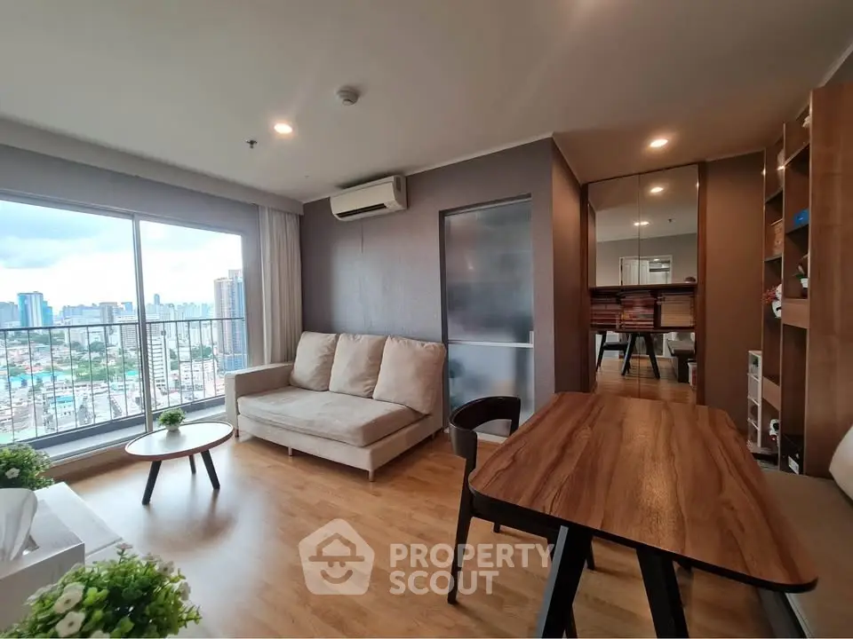 Modern living room with city view, wooden flooring, and stylish furniture in a high-rise apartment.