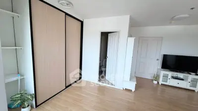 Spacious modern living room with wooden flooring and built-in wardrobe