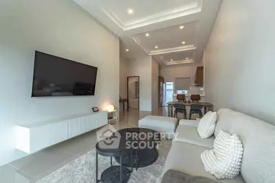 Modern living room with sleek furniture and wall-mounted TV in open layout.