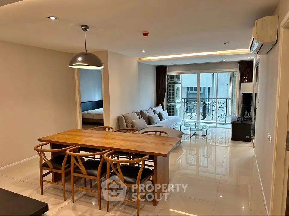 Spacious modern living room with dining area and balcony access in a stylish apartment.