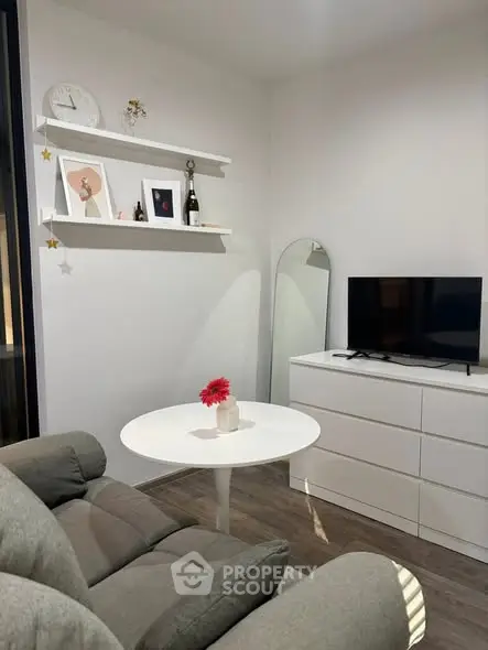 Cozy living room with modern decor, featuring a sleek TV setup and stylish shelving.