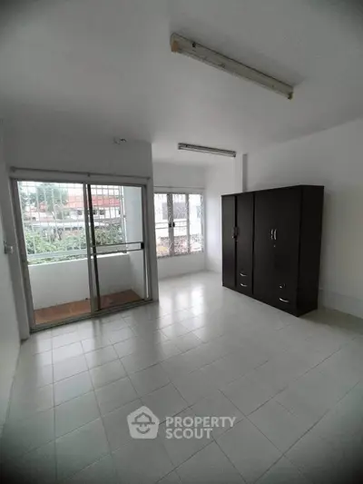 Spacious unfurnished room with large windows and wardrobe, ideal for customization.