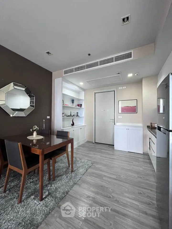 Modern dining area with stylish decor and open kitchen layout in a contemporary apartment.
