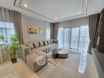 Spacious modern living room with large sofa and floor-to-ceiling windows
