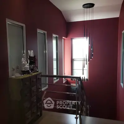 Stylish stairway with modern lighting and red accent walls in a contemporary home.