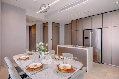 Modern kitchen with sleek cabinetry and elegant dining setup in luxury apartment.