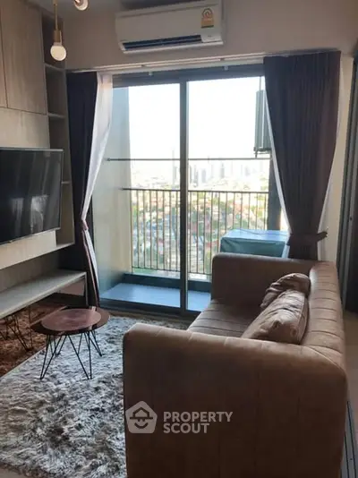 Modern living room with balcony view, stylish furniture, and natural light.