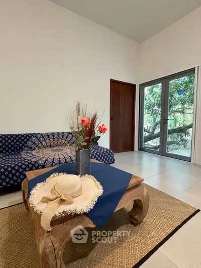 Charming living room with cozy decor and garden view, perfect for relaxation.