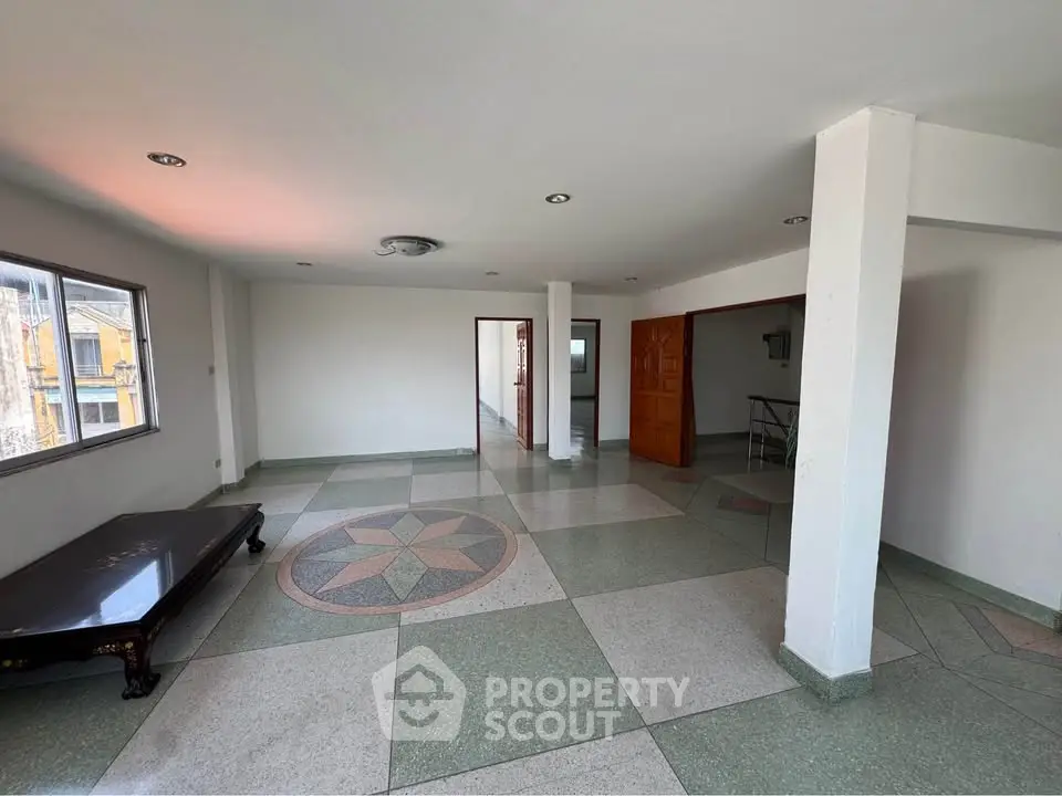 Spacious living room with unique tiled flooring and ample natural light.