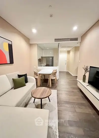 Modern living room with stylish decor and open layout, featuring a cozy sofa and dining area.