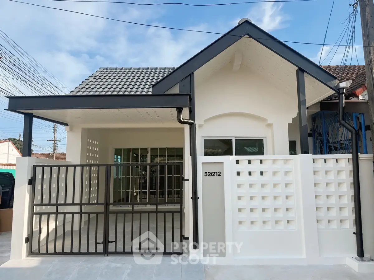 Charming single-story house with modern facade and gated entrance in a serene neighborhood.