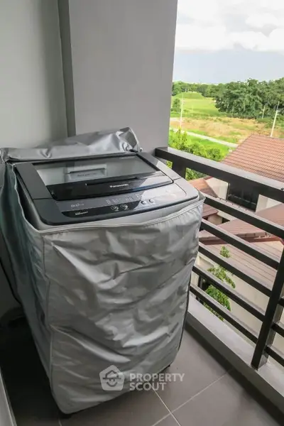 Balcony with washing machine and scenic view of green landscape